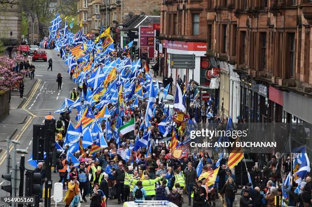 Thousands of demonstrators carry Saltire flags, the national flag of Scotland, as they march in support of Scottish independence through the streets...