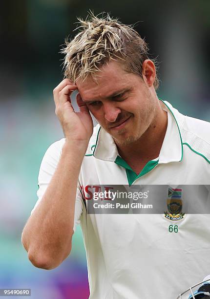 Paul Harris of South Africa walks off after losing his wicket to James Anderson of England for 36 runs when he was caught out by Stuart Broad during...