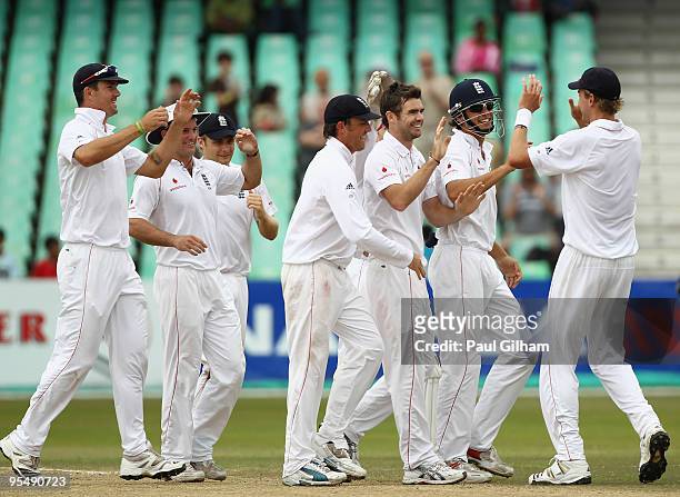James Anderson of England celebrates with his team-mates after taking the wicket of Paul Harris of South Africa for 36 runs when he was caught out by...