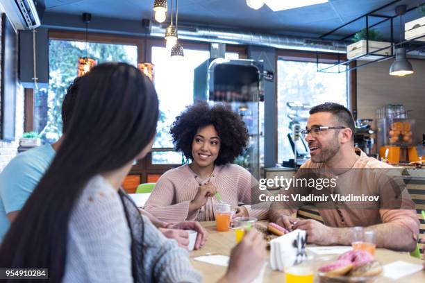 group of young people talking and eating ice cream in cafe - ice cream cake stock pictures, royalty-free photos & images