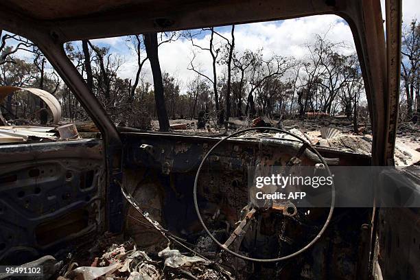 Burntout vehicle is pictured amongst the devastation at a property on Adenanthus Road after an overnight fire roared through the Lloyds Hill...