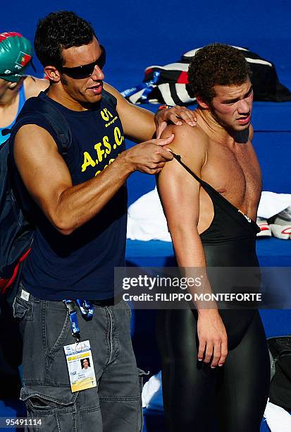 Member of team Paraguay helps a teammate to put on a Jaked swimsuit during a training session on July 25, 2009 at the FINA World Championships in...