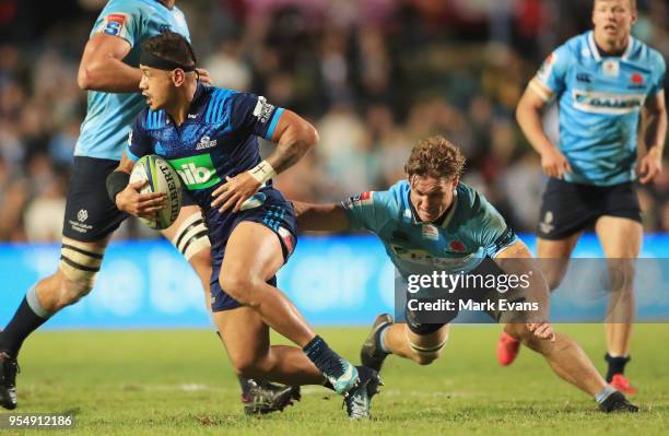 Augustine Pulu of the Blues is tackled by Michael Hooper of the Waratahs during the round 12 Super Rugby match between the Waratahs and the Blues at...