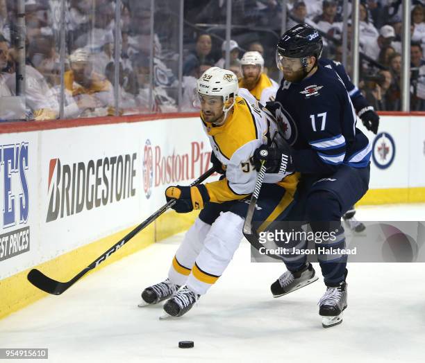 Adam Lowry of the Winnipeg Jets and Roman Josi of the Nashville Predators fight for the puck in Game Four of the Western Conference Second Round...