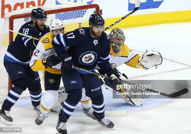 Pekka Rinne of the Nashville Predators follows the puck as Bryan Little and Adam Lowry of the Winnipeg Jets battle with Matt Irwin in Game Four of...