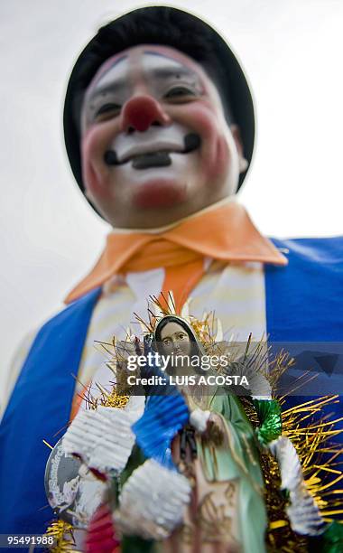 Mexican clown holds a statuette of the Virgin of Guadalupe, Mexico's patron saint, in Mexico City on December 16, 2009. Hundreds of clowns arrived at...