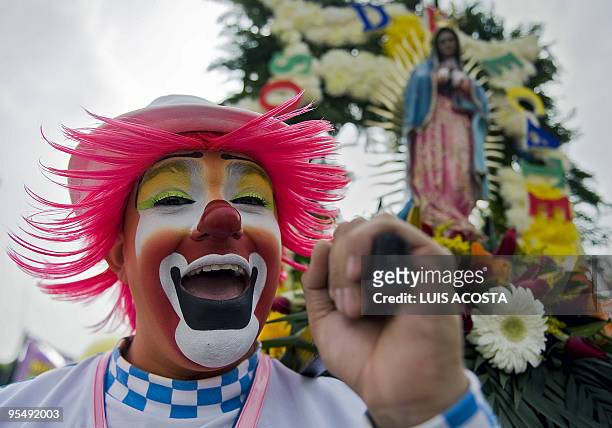 Mexican clown holds a statuette of the Virgin of Guadalupe, Mexico's patron saint, in Mexico City on December 16, 2009. Hundreds of clowns arrived at...
