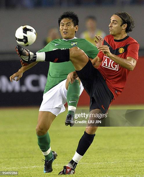 Manchester United's Dimitar Berbatov fights for the ball with Chang Lin of Hangzhou Greentown during a friendly football match in Hangzhou, in...