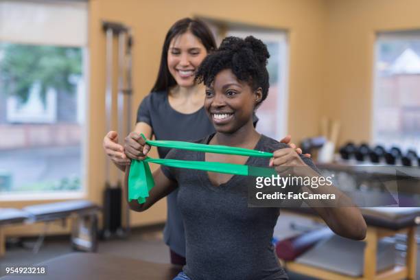 physical therapy session with two women of color - sports physiotherapy stock pictures, royalty-free photos & images