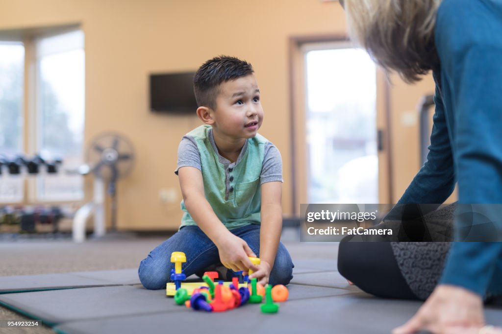 Occupational therapist works with a young ethnic boy