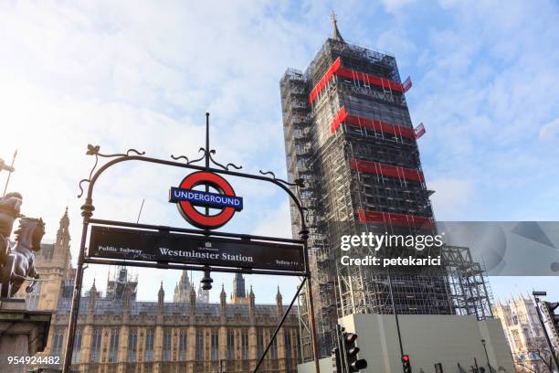 westminster station entrance and big ben in london at day - roundel stock pictures, royalty-free photos & images