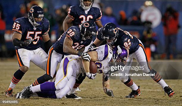 Jeff Dugan of the Minnesota Vikings is brought down by Danieal Manning and Hunter Hillenmeyer of the Chicago Bears as teammate Lance Briggs moves in...