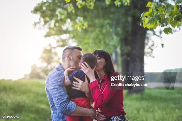 young family kissing each other - adoption stock pictures, royalty-free photos & images