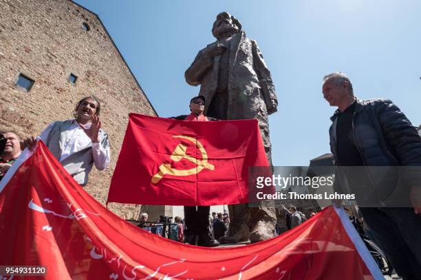 Marco Urquieta visitor of Bolivia stands with a communistic flag in front of the sculpture of German philosopher and revolutionary Karl Marx after...