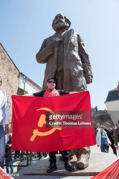 Marco Urquieta visitor of Bolivia stands with a communistic flag in front of the sculpture of German philosopher and revolutionary Karl Marx after...