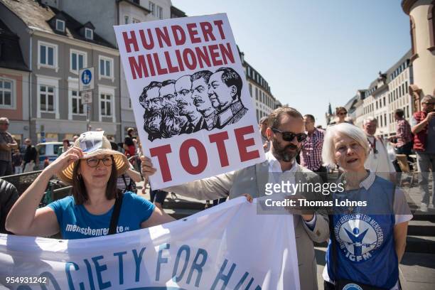 People demonstrate against communism near the sculpture of German philosopher and revolutionary Karl Marx during its inauguration at the 200th...