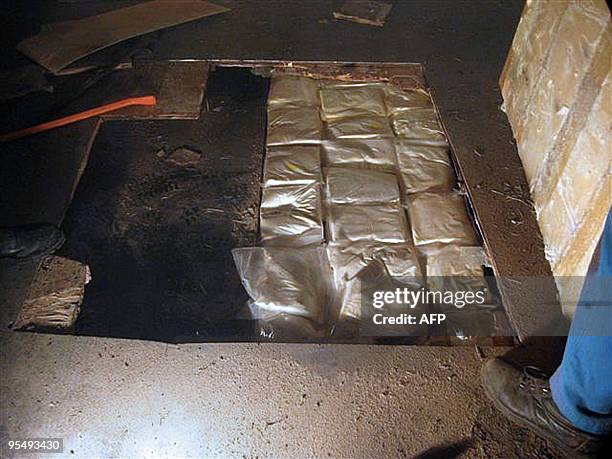 Une personne se tient près d'une cache dans un camion frigorifique dans laquelle ont été saisis 250 kg d'amphétamines et de cocaïne par les douaniers...