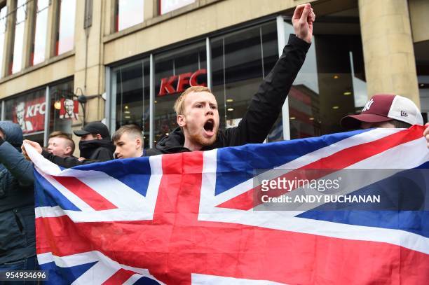 An anti-independence supporter holds a Union Flag and shouts slogans as thousands of demonstrators carrying Saltire flags, the national flag of...