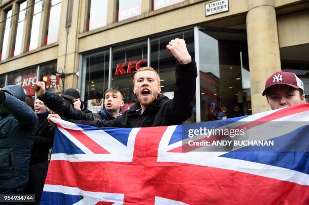 An anti-independence supporter holds a Union Flag and shouts slogans as thousands of demonstrators carrying Saltire flags, the national flag of...