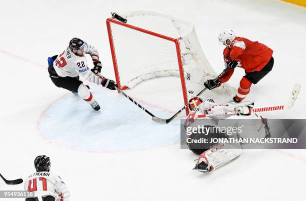 Switzerland's Enzo Corvi strikes behind Austria's goalie Bernhard Starkbaum to score the game-winning goal at overtime during the group A match...