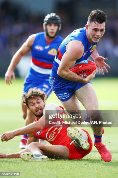 Toby McLean of the Bulldogs runs with the ball from Jarrod Harbrow of the Suns during the round seven AFL match between the Western Bulldogs and the...