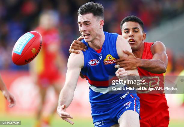 Touk Miller of the Suns tackles Toby McLean of the Bulldogs during the round seven AFL match between the Western Bulldogs and the Gold Coast Suns at...