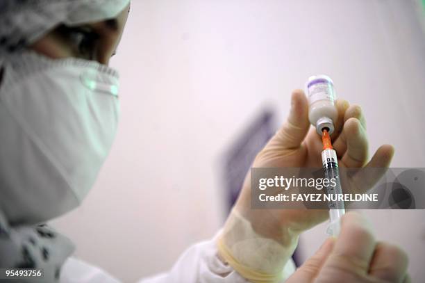 An Algerian doctor prepares a vaccine dose against the H1N1 flu at 'Beni Mesouss' hospital, on December 30, 2009 in Algiers. Algeria launched a...