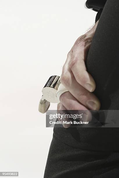 Detail view of a whistle on a referee's left hand as he rests his hand on his knee during a break in play of a game between the St. Louis Blues and...