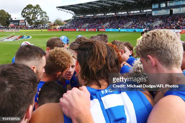 Lachie Hunter of the Bulldogs speaks to teammates in the huddle during the round seven AFL match between the Western Bulldogs and the Gold Coast Suns...