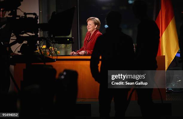 German Chancellor Angela Merkel chats with a television crew moments after delivering her New Year's television address to the nation at the...