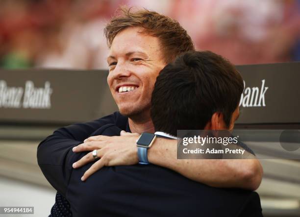 Julian Nagelsmann head coach of 1899 Hoffenheim hugs Tayfun Korkut head coach of VfB Stuttgart during the Bundesliga match between VfB Stuttgart and...