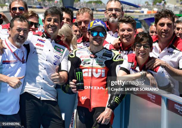 Honda's British rider Cal Crutchlow celebrates with his team being first placed during the MotoGP qualifying session of the Spanish Grand Prix at the...