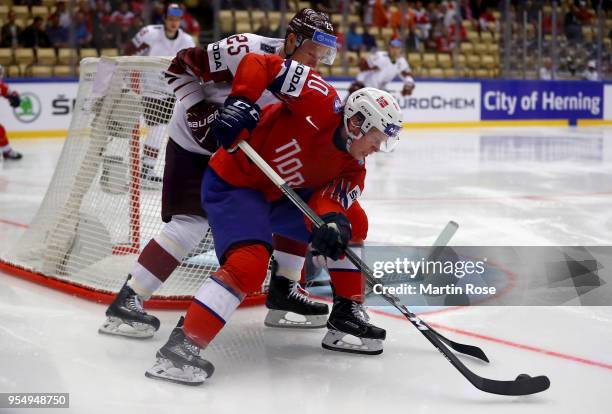 Ken Andre Olimb of Norway and Andris Dzerins of Latvia battle for the puck during the 2018 IIHF Ice Hockey World Championship group stage game...