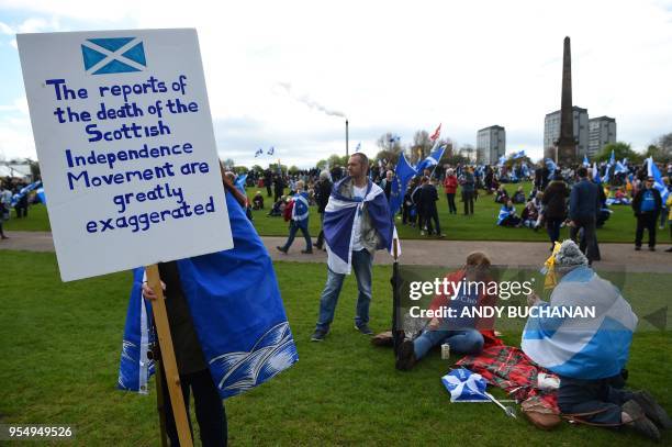 Pro-independence demonstrators with Saltire flags, the national flag of Scotland, relax after a march in support of Scottish independence, through...