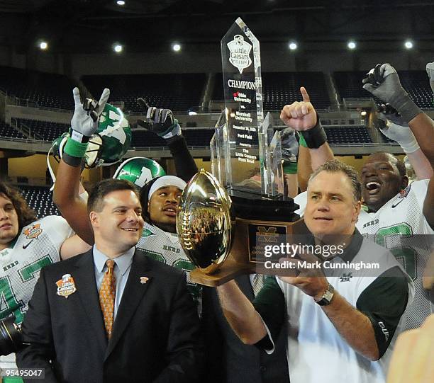 Marshall University Thundering Herd Interim Head Coach Rick Minter raises the Championship Trophy into the air to celebrate the victory against the...