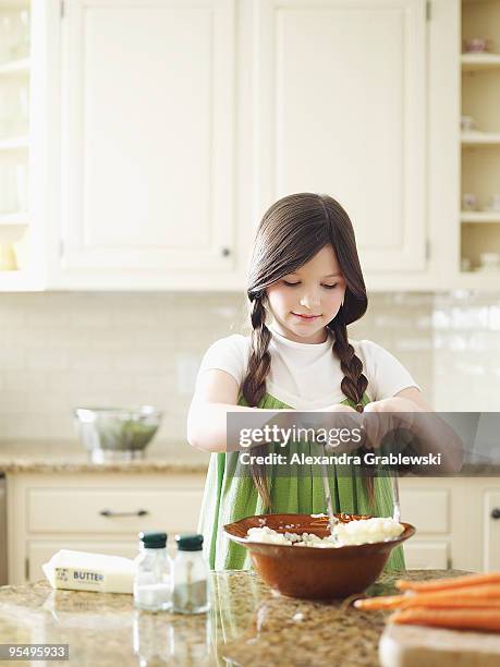 girl mashing potatoes. - potato masher stockfoto's en -beelden