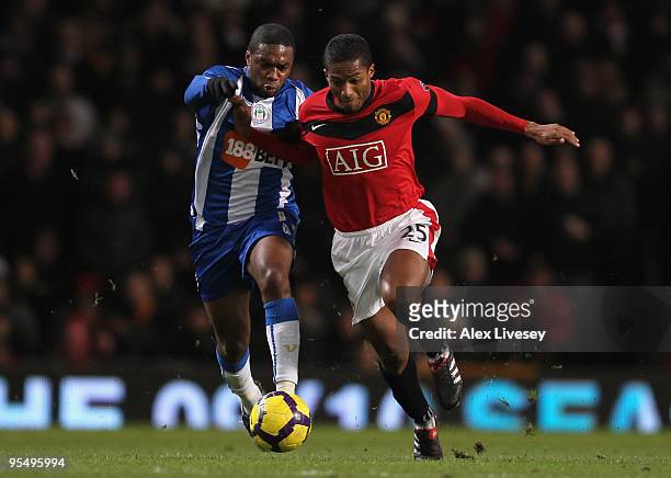 Charles N' Zogbia of Wigan Athletic battles for the ball with Antonio Valencia of Manchester United during the Barclays Premier League match between...