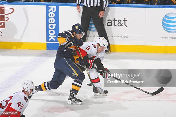 Milan Michalek of the Ottawa Senators skates for the puck against Filip Kuba of the Buffalo Sabres on December 26, 2009 at HSBC Arena in Buffalo, New...