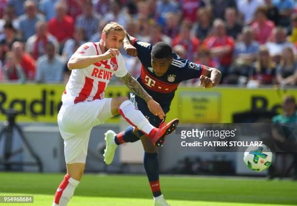 Cologne's German midfielder Marcel Risse and Bayern Munich's forward Franck Evina vie for the ball during the German first division Bundesliga...