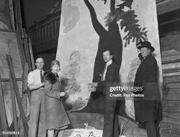 English designer Cecil Beaton and writer Osbert Sitwell painting a theatre backdrop, May 1928.