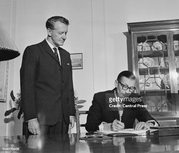 Rhodesian Prime Minister Ian Smith watches Clifford Dupont , the Officer Administrating the Government of Rhodesia, sign the new constitution bill in...