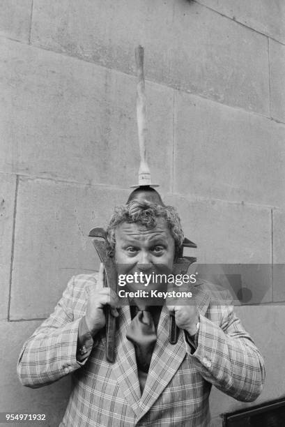 Welsh actor and singer Harry Secombe poses with a plumber's tools during rehearsals for the comedy 'Schippel' at the Prince of Wales Theatre in...