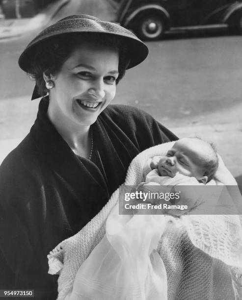 English actress Jean Lodge poses with her baby son Charles George Patrick Shaughnessy after his christening at St James's, Spanish Place, London,...