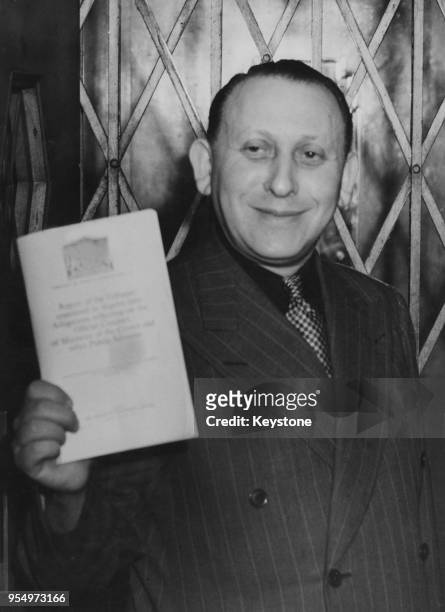 Polish businessman Sidney Stanley holds a copy of the Lynskey Tribunal Report at his flat in Park Lane, London, 25th January 1949.