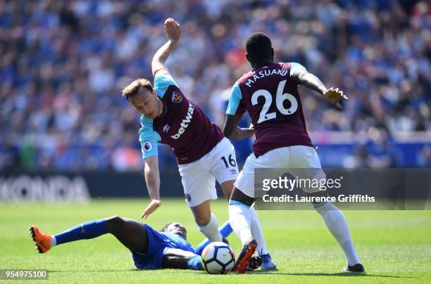 Fousseni Diabate of Leicester City goes down as Mark Noble and Arthur Masuaku of West Ham United control the ball during the Premier League match...