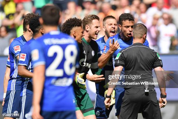 Players of Schalke argue with referee Robert Kampka during the Bundesliga match between FC Augsburg and FC Schalke 04 at WWK-Arena on May 5, 2018 in...
