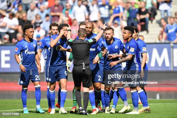 Players of Schalke argue with referee Robert Kampka during the Bundesliga match between FC Augsburg and FC Schalke 04 at WWK-Arena on May 5, 2018 in...