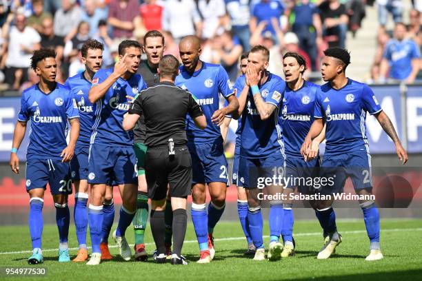 Players of Schalke argue with referee Robert Kampka during the Bundesliga match between FC Augsburg and FC Schalke 04 at WWK-Arena on May 5, 2018 in...