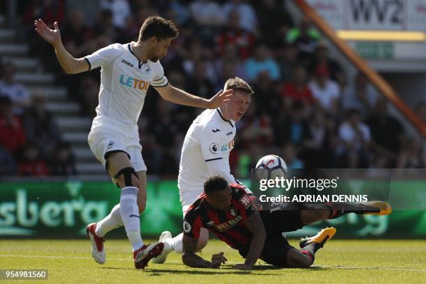 Swansea City's Argentinian defender Federico Fernandez and Swansea City's English defender Alfie Mawson bring down Bournemouth's English striker...