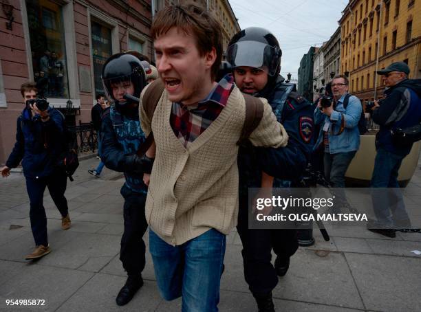 Russian police officers detain a protester during an unauthorized anti-Putin rally called by opposition leader Alexei Navalny on May 5, 2018 in Saint...